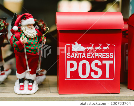 A red Santa Express Post box with a man dressed as Santa standing next to it. Christmas A red Santa Express Post box with a man dressed as Santa standing next to it. Christmas 130733704