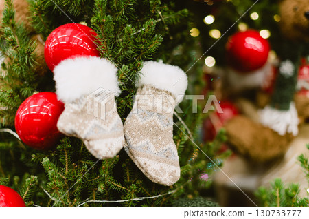 A christmas tree with a pair of red and white socks hanging from it A christmas tree with a pair of red and white socks hanging from it 130733777