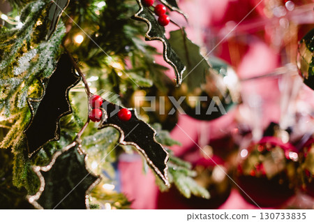 A Christmas tree with a black and red leafy branch 130733835