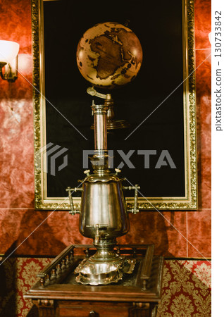 A silver tea kettle sits on a wooden table A silver tea kettle sits on a wooden table 130733842