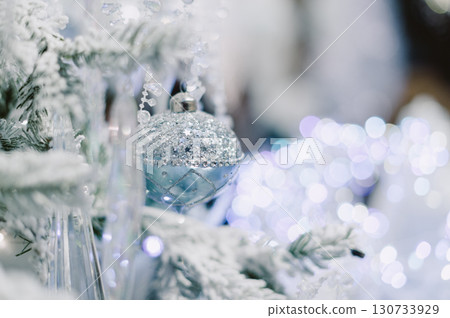 A Christmas tree with a blue ornament hanging from it 130733929
