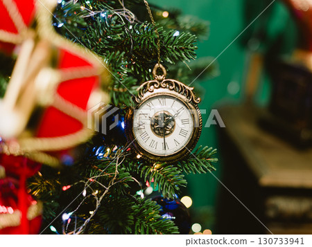 A gold and white clock hanging from a green background A gold and white clock hanging from a green background 130733941