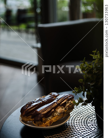 A plate of chocolate covered doughnuts sits on a table A plate of chocolate covered doughnuts sits on a table 130733963