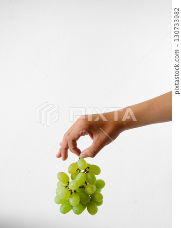 A hand holding a bunch of grapes A hand holding a bunch of grapes 130733982