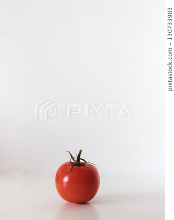 A red tomato sits on a white background A red tomato sits on a white background 130733983