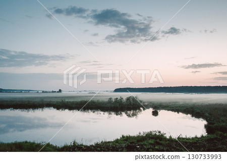 A lake with a cloudy sky in the background A lake with a cloudy sky in the background 130733993
