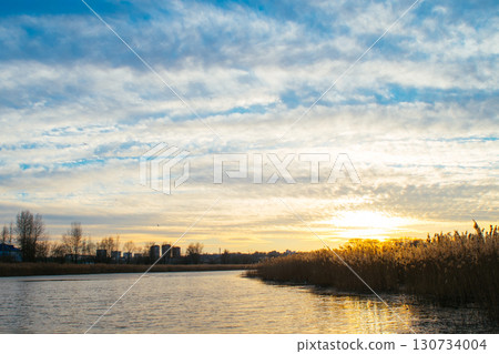 A beautiful sunset over a lake with a city in the background A beautiful sunset over a lake with a city in the background 130734004