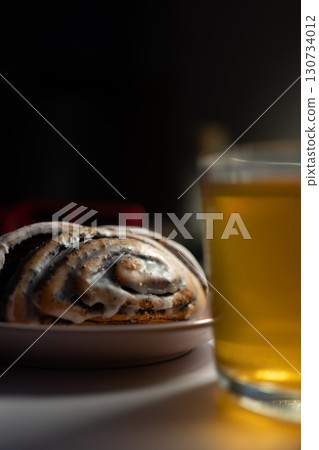 A cinnamon roll with sugar and cup of tea. Breakfast food. Top view. Rustic scene A cinnamon roll with sugar and cup of tea. Breakfast food. Top view. Rustic scene 130734012