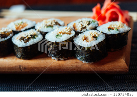 A plate of sushi with a garnish of red ginger A plate of sushi with a garnish of red ginger 130734053