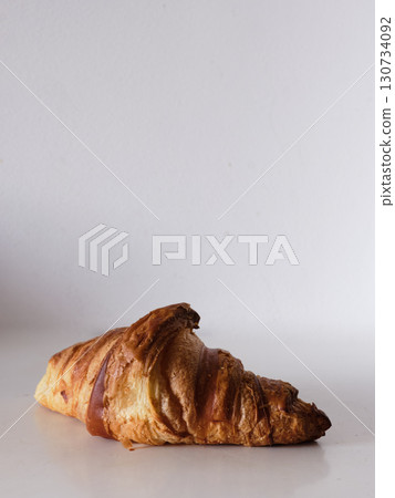 A croissant is sitting on a white background 130734092