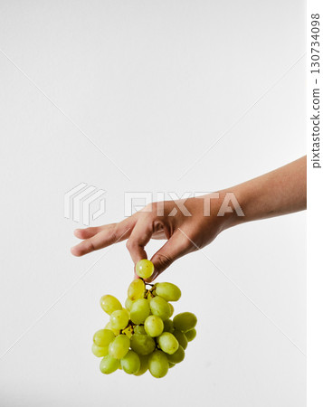 A hand holding a bunch of grapes A hand holding a bunch of grapes 130734098