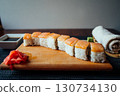 A plate of sushi with a roll of seaweed on the side 130734130