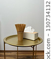 A tray with a white tissue box and a cup of straws on it 130734132