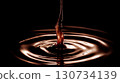Drop of chocolate is falling into a pool of chocolate. Moody and dark atmosphere 130734139