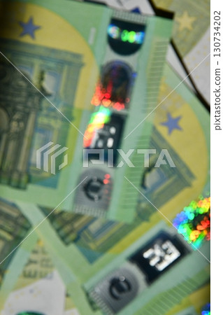 Euro currency with holographic elements blurry background showcasing intricate design patterns Euro currency with holographic elements blurry background showcasing intricate design patterns 130734202