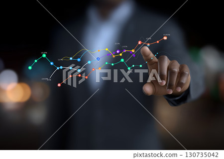 Businessman Pointing at Digital Data Graphs Businessman Pointing at Digital Data Graphs 130735042