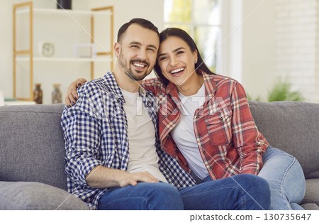 Portrait of Caucasian young couple in love sitting on sofa smiling and hugging. Portrait of Caucasian young couple in love sitting on sofa smiling and hugging. 130735647