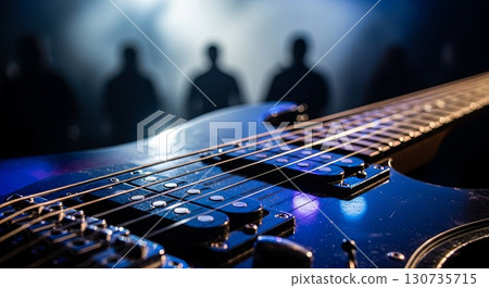 Close-up of Electric Guitar with Blurred Band Silhouettes on Stage 130735715