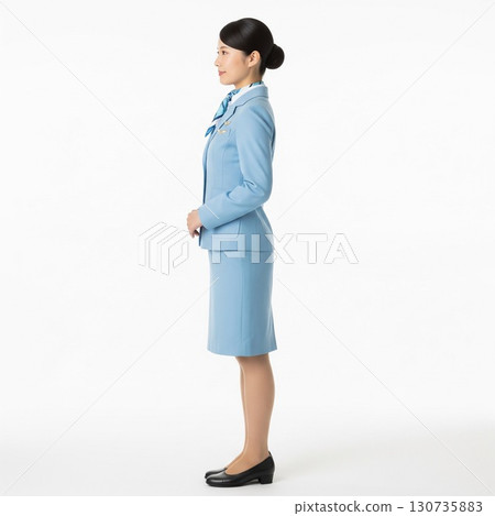 Full-length side view of a smiling flight attendant standing with her back straight (white background) 130735883