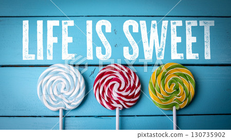 Colorful lollipops on blue background with Sweet Life message 130735902