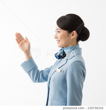 面帶微笑的空服員用手給予指示（側面，白色背景） 130736342