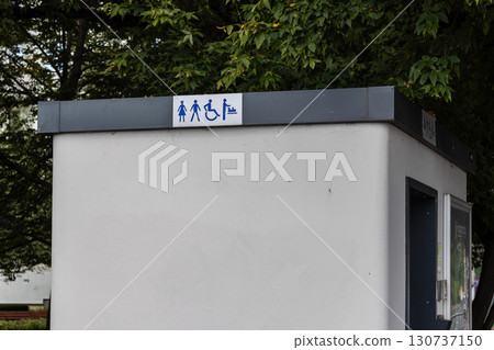 Public convenience building features a universal access sign for men, women, disabled persons, and baby changing, highlighting essential urban facilities and inclusivity 130737150