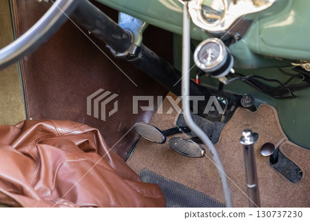 Vintage automobile interior view highlighting classic accelerator and brake pedals, steering wheel, and dashboard, capturing timeless automotive history and nostalgic travel Vintage automobile interior view highlighting classic accelerator and brake pedals, steering wheel, and dashboard, capturing timeless automotive history and nostalgic travel 130737230