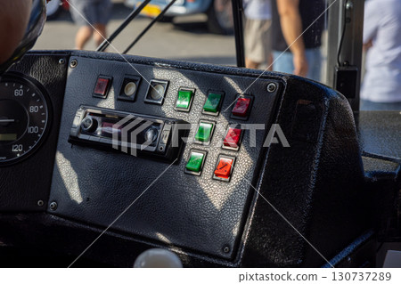 Classic vehicle dashboard with speedometer, audio system, and colorful toggle switches, reflecting vintage transport, industrial control, and essential mechanical design 130737289