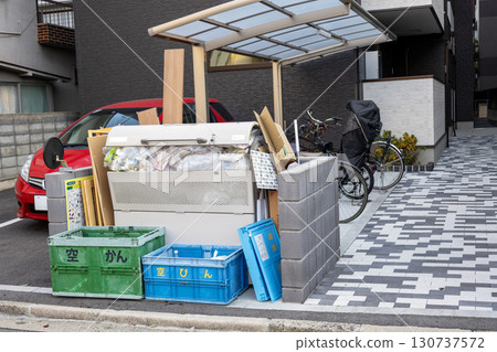A garbage dumpster in an apartment complex filled with garbage A garbage dumpster in an apartment complex filled with garbage 130737572