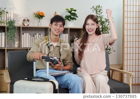 Travel Excitement. Young couple celebrating their trip plans with luggage and camera. Travel Excitement. Young couple celebrating their trip plans with luggage and camera. 130737885