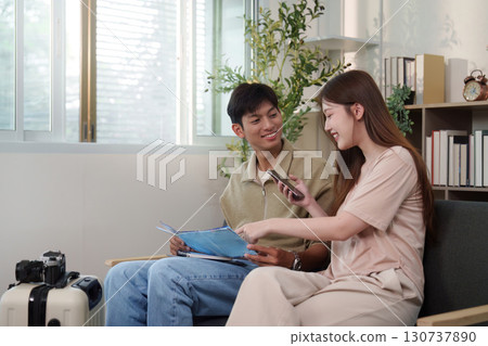 Travel Planning. Young couple excitedly discussing their upcoming trip at home. Travel Planning. Young couple excitedly discussing their upcoming trip at home. 130737890
