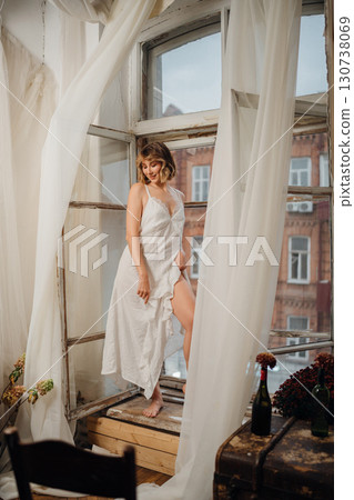 Beautiful and slender young woman in a long white dress with bare feet. Beautiful and slender young woman in a long white dress with bare feet. 130738069