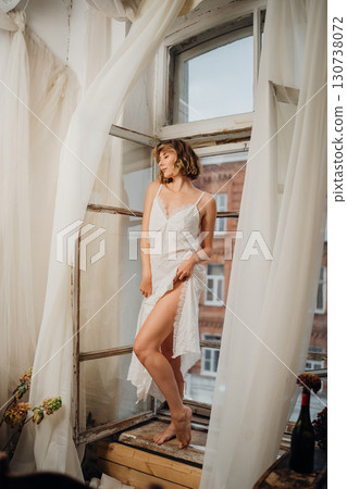 Beautiful and slender young woman in a long white dress with bare feet. Beautiful and slender young woman in a long white dress with bare feet. 130738072