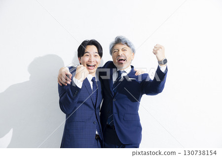 Two businessmen standing side by side Two businessmen standing side by side 130738154