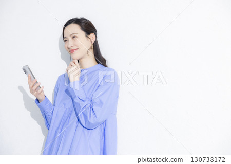 A young woman looking at her smartphone and having trouble A young woman looking at her smartphone and having trouble 130738172