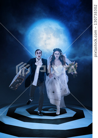 Zombie wedding couple running with suitcase and flowers under full moon Zombie wedding couple running with suitcase and flowers under full moon 130738302