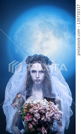 Gothic bride holding wilted bouquet under full moon surreal scene 130738317