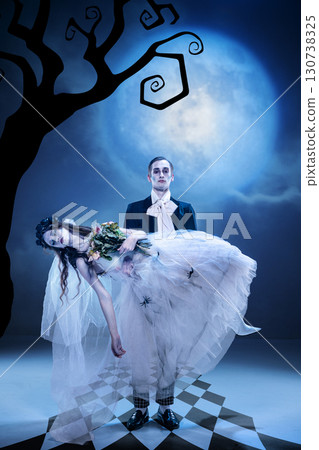 Gothic groom carrying ghost bride under full moon with eerie bouquet 130738325