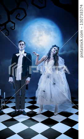 Gothic wedding couple posing in eerie moonlight with surreal gestures Gothic wedding couple posing in eerie moonlight with surreal gestures 130738374