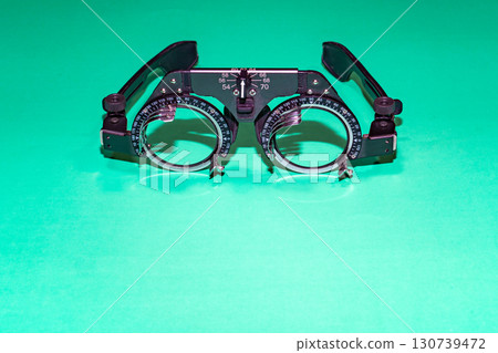 Optometry optics test glasses on a green table. High quality photo Optometry optics test glasses on a green table. High quality photo 130739472