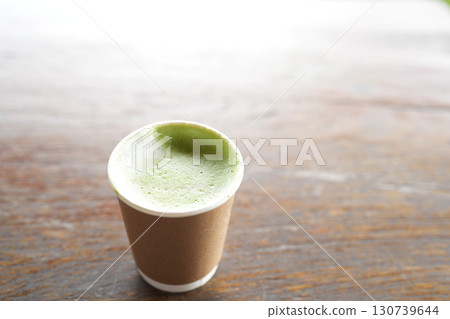 Matcha green tea in a paper cup on wooden table 130739644