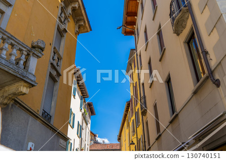 Narrow Italian street in Como city. Multicolor old house building architecture. Windows Narrow Italian street in Como city. Multicolor old house building architecture. Windows 130740151
