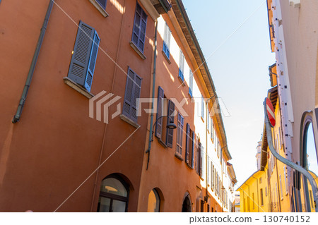 Narrow Italian street in Como city. Multicolor old house building architecture. Windows Narrow Italian street in Como city. Multicolor old house building architecture. Windows 130740152