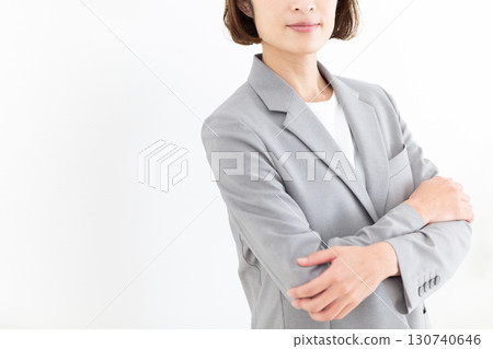一位身穿灰色西裝、面帶微笑的中年女商人 130740646