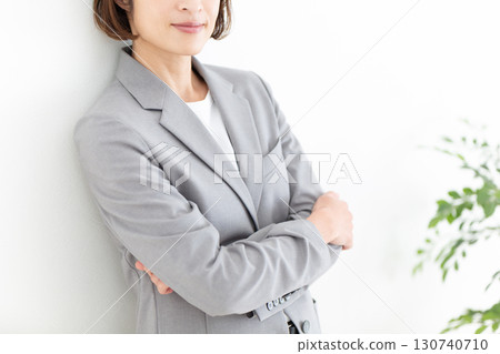 A middle-aged businesswoman wearing a gray suit and smiling A middle-aged businesswoman wearing a gray suit and smiling 130740710