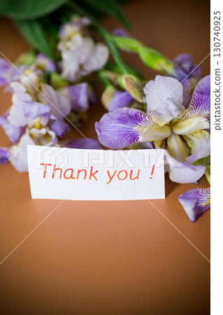 Fresh cut irises with bright greenery on a brown background Fresh cut irises with bright greenery on a brown background 130740925