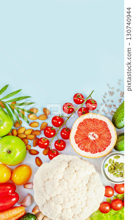 Organic farm vegetables, fruits, olive oil, nuts, seeds and plant yogurt on blue background with copy space. The concept of vegan, vegetarian healthy food, diet and detox. Smartphone format, flat lay 130740944