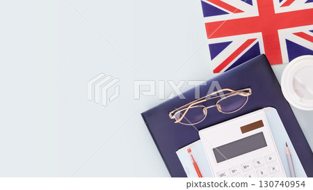 Great Britain education banner with laptop, glasses, calculator, coffee cup and flag of UK on a blue background with copy space. Concept of Education in the Great Britain. Flat lay 130740954