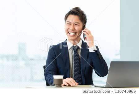 微笑的男性商人在智慧型手機上交談 微笑的男性商人在智慧型手機上交談 130740969