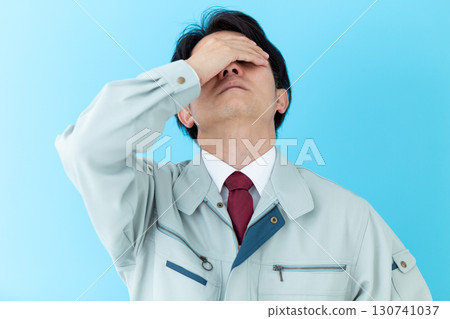 A middle-aged male businessman wearing work clothes who is worried 130741037